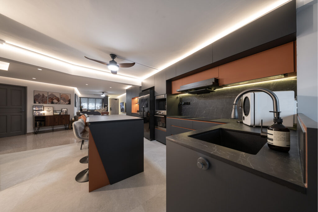 Open-concept kitchen with a sleek black island and dark cabinetry in a resale HDB renovation.